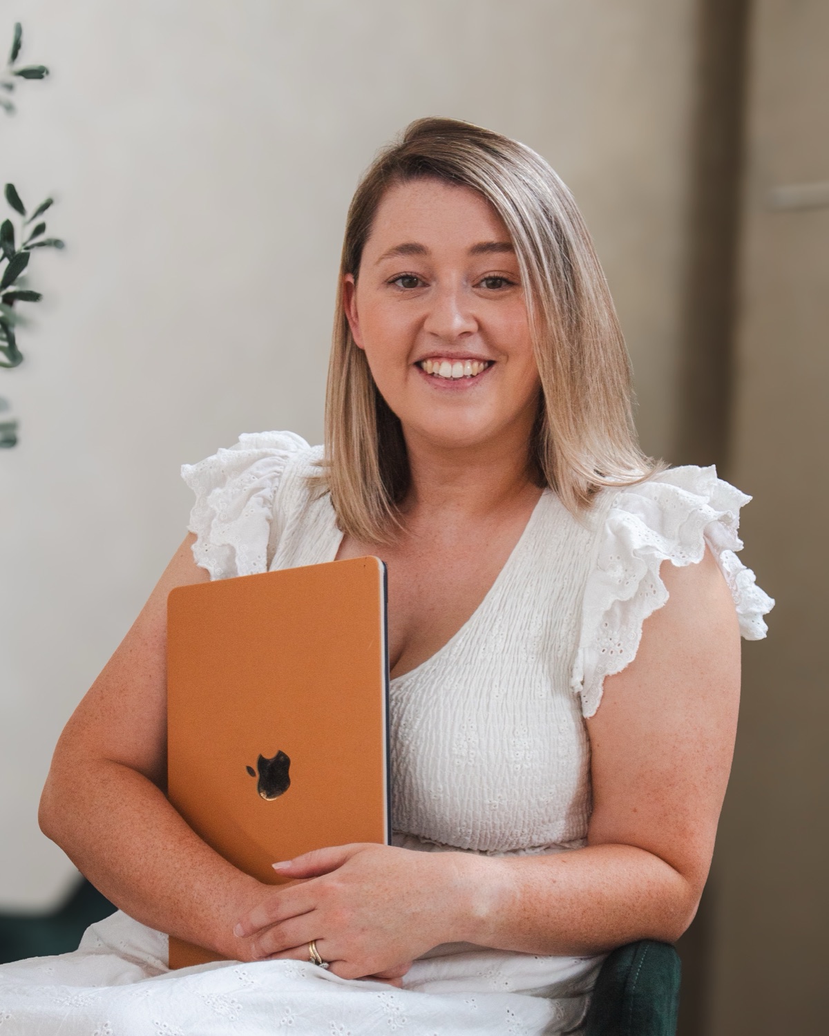 Lauren smiling, holding her laptop