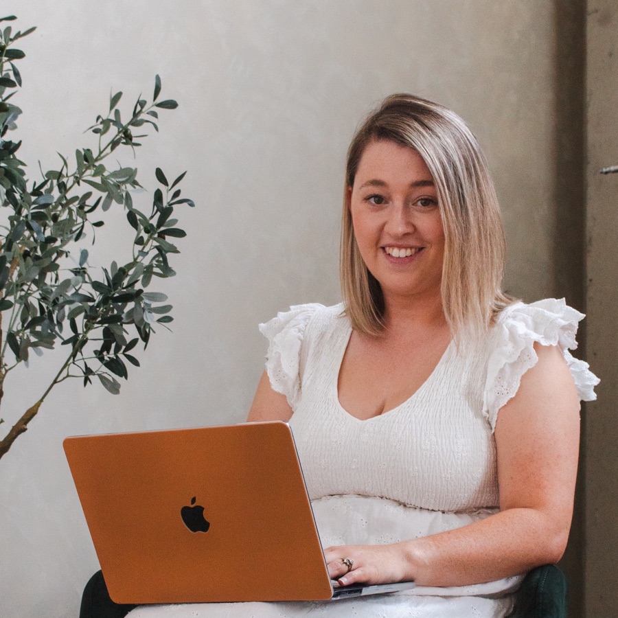 Lauren smiling while working on her laptop